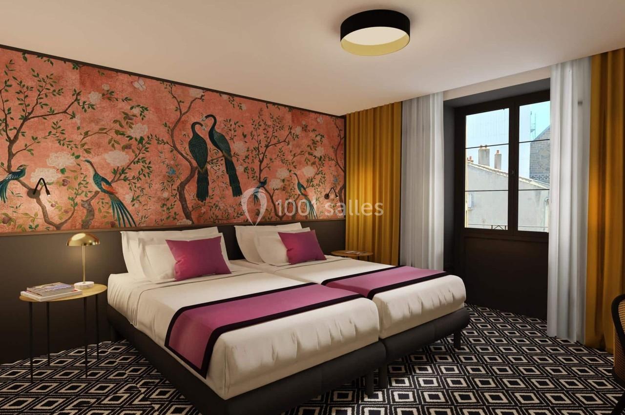 Chambre avec deux lits simples, décorée d'un papier peint à motifs d'oiseaux et de rideaux jaunes et blancs.