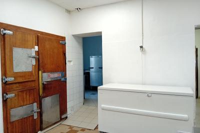 Cuisine professionnelle équipée avec plans de travail en inox, cuisinières, hotte et four à micro-ondes.