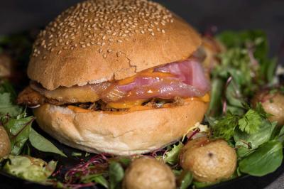 Vue rapprochée d'une mousse de café garnie de grains de café entiers dans un verre transparent.