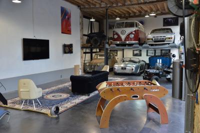 Clocher d'église avec horloge visible, entouré de bâtiments en briques et de végétation sous un ciel bleu.