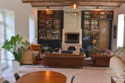 Clocher d'église avec horloge visible, entouré de bâtiments en briques et de végétation sous un ciel bleu.