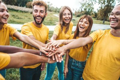 Trois pots de rillettes de canard et de poulet posés sur un lit de feuilles vertes en extérieur.