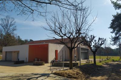 Douche moderne avec paroi vitrée, pommeau mural et lavabo blanc dans une salle de bain aux murs clairs.