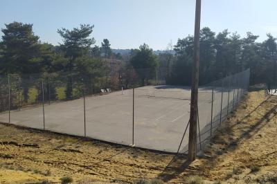 Douche moderne avec paroi vitrée, pommeau mural et lavabo blanc dans une salle de bain aux murs clairs.