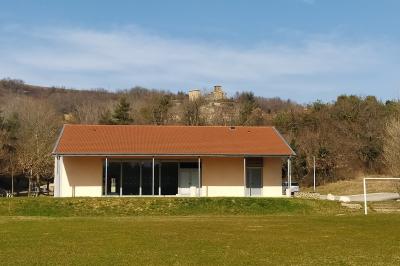 Douche moderne avec paroi vitrée, pommeau mural et lavabo blanc dans une salle de bain aux murs clairs.