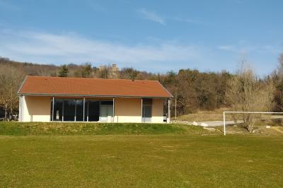 Douche moderne avec paroi vitrée, pommeau mural et lavabo blanc dans une salle de bain aux murs clairs.