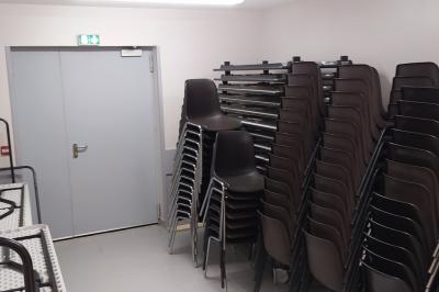 Douche moderne avec paroi vitrée, pommeau mural et lavabo blanc dans une salle de bain aux murs clairs.