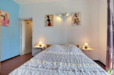 Douche moderne avec paroi vitrée, pommeau mural et lavabo blanc dans une salle de bain aux murs clairs.