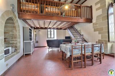 Douche moderne avec paroi vitrée, pommeau mural et lavabo blanc dans une salle de bain aux murs clairs.