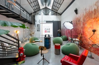 Femme jouant de la guitare électrique dans un décor rétro avec des objets dorés et un téléphone ancien sur une table en…