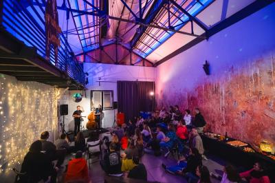 Femme jouant de la guitare électrique dans un décor rétro avec des objets dorés et un téléphone ancien sur une table en…