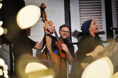 Femme jouant de la guitare électrique dans un décor rétro avec des objets dorés et un téléphone ancien sur une table en…