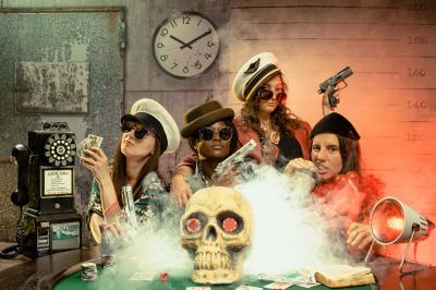 Femme jouant de la guitare électrique dans un décor rétro avec des objets dorés et un téléphone ancien sur une table en…