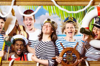 Femme portant des lunettes en forme de cœur jouant de la guitare électrique dans un décor rétro avec objets dorés.