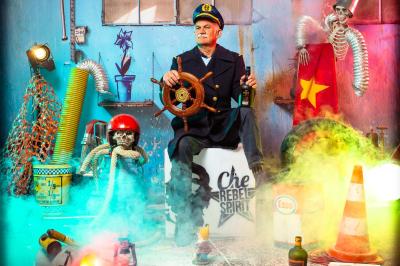 Femme portant des lunettes en forme de cœur jouant de la guitare électrique dans un décor rétro avec objets dorés.