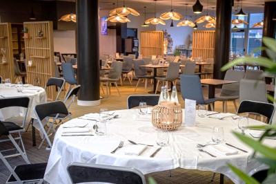 Plusieurs Citroën 2CV colorées alignées sur un parking ensoleillé.