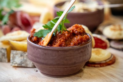 Plusieurs Citroën 2CV colorées alignées sur un parking ensoleillé.