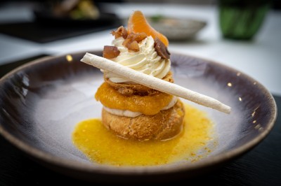 Plusieurs Citroën 2CV colorées alignées sur un parking ensoleillé.