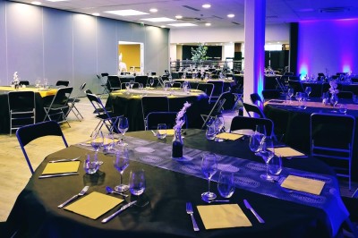 Plusieurs Citroën 2CV colorées alignées sur un parking ensoleillé.