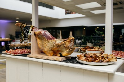 Plusieurs Citroën 2CV colorées alignées sur un parking ensoleillé.