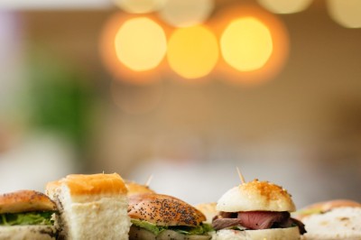 Plusieurs Citroën 2CV colorées alignées sur un parking ensoleillé.