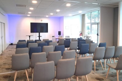 Plusieurs Citroën 2CV colorées alignées sur un parking ensoleillé.