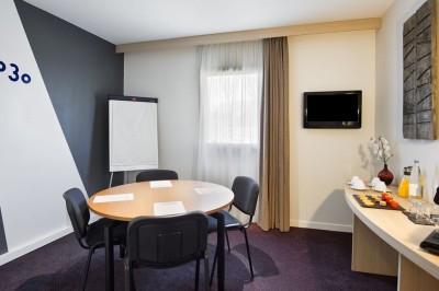 Plusieurs Citroën 2CV colorées alignées sur un parking ensoleillé.