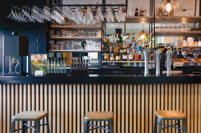 Plusieurs Citroën 2CV colorées alignées sur un parking ensoleillé.