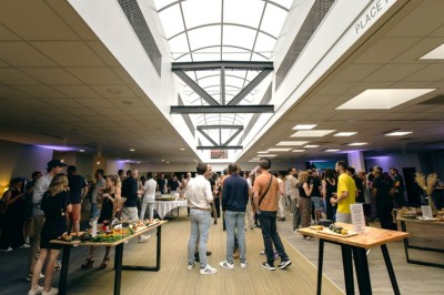 Plusieurs Citroën 2CV colorées alignées sur un parking ensoleillé.