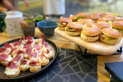 Plusieurs Citroën 2CV colorées alignées sur un parking ensoleillé.