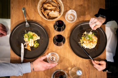 Plusieurs Citroën 2CV colorées alignées sur un parking ensoleillé.