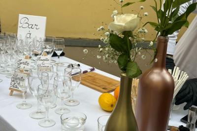 Table dressée avec des verres, des bouteilles décoratives, des citrons et un panneau indiquant un bar à spritz.