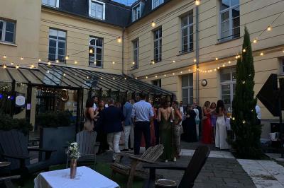 Table dressée avec des verres, bouteilles décoratives, une rose blanche et des citrons, devant un panneau ’Bar’.