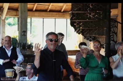 Des personnes souriantes dans un intérieur lumineux, certaines tenant des instruments de musique ou applaudissant.