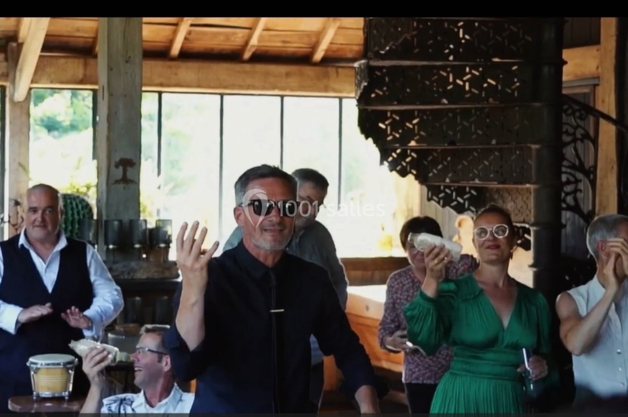 Des personnes souriantes dans un intérieur lumineux, certaines tenant des instruments de musique ou applaudissant.