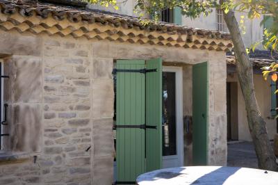 Salle à manger et salon avec table en bois, canapés clairs, lampes suspendues et lumière naturelle.