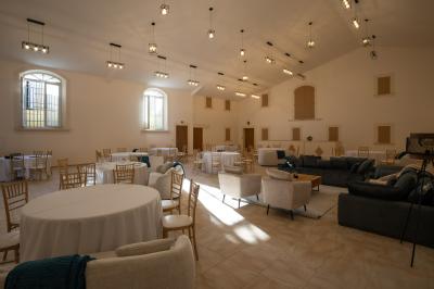 Salle à manger et salon avec table en bois, canapés clairs, lampes suspendues et lumière naturelle.