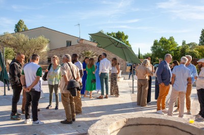 Salle à manger et salon avec table en bois, canapés clairs, lampes suspendues et lumière naturelle.