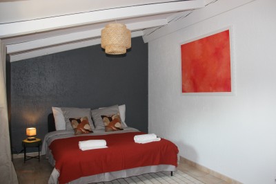 Salle à manger et salon avec table en bois, canapés clairs, lampes suspendues et lumière naturelle.