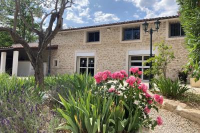 Allée pavée éclairée par des guirlandes lumineuses, menant à une pergola blanche dans un jardin nocturne.