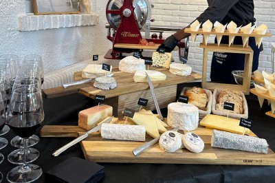 Plateau de mini-sandwiches variés, wraps et brochettes apéritives avec tomates cerises, présenté dans une boîte ouverte.