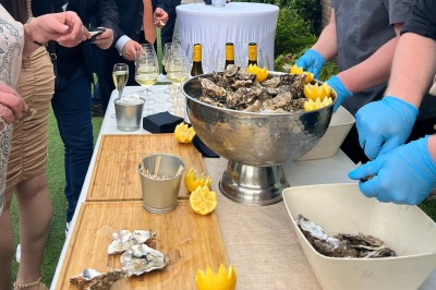 Plateau de mini-sandwiches variés, wraps et brochettes apéritives avec tomates cerises, présenté dans une boîte ouverte.