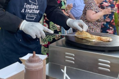 Plateau de mini-sandwiches variés, wraps et brochettes apéritives avec tomates cerises, présenté dans une boîte ouverte.