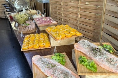 Miniature Traiteur Leers (Nord) - Tendance et Fraicheur Traiteur #15 Brochettes de viande et légumes grillant sur un barbecue en plein air, avec une fontaine et un jardin en arrière-plan.