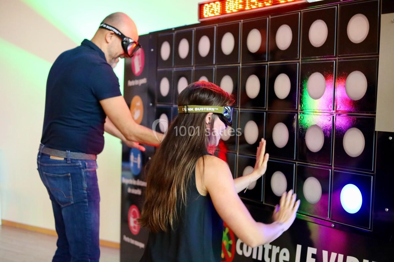 Deux personnes portant des lunettes spéciales interagissent avec un mur lumineux dans un environnement intérieur.