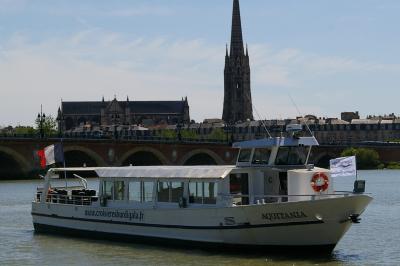 Bateau naviguant sur un fleuve devant un bâtiment historique avec une architecture classique.