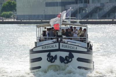 Bateau naviguant sur un fleuve devant un bâtiment historique avec une architecture classique.