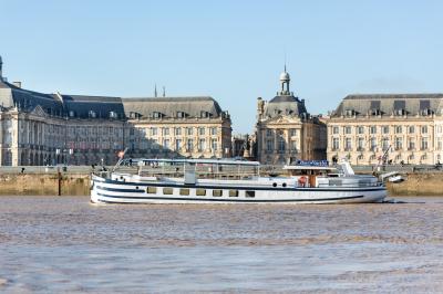 Bateau naviguant sur un fleuve devant un bâtiment historique avec une architecture classique.