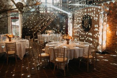 Un couple en tenue de mariage se tient devant un officiant dans un décor festif avec sapins et guirlandes lumineuses.
