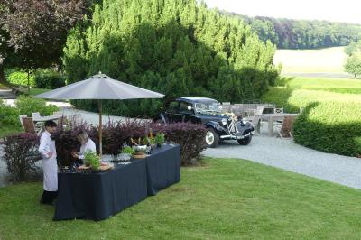 Un couple en tenue de mariage se tient devant un officiant dans un décor festif avec sapins et guirlandes lumineuses.